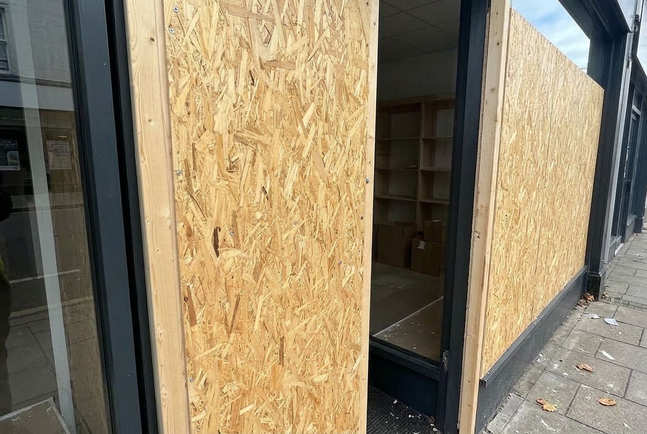 Residential ground floor window covered with plywood boards