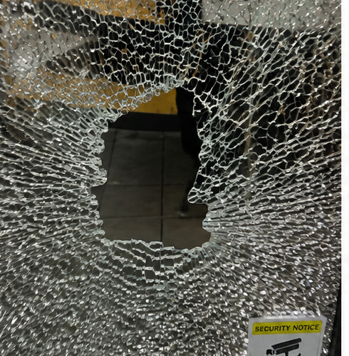 Close-up of smashed safety glass with hole