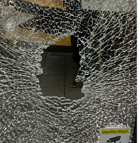Close-up of smashed safety glass with hole