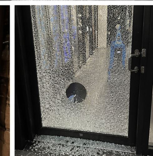 Smashed glass shop door secured awaiting repair